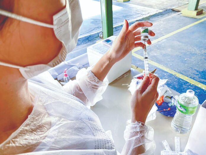 Agente da Saúde prepara dose de vacina em Cruzeiro; cidade cria sistema de informações via WhatsApp (Reprodução PMC)